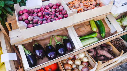 Organic vegetables in rustic wooden crates for sale at Farmers Market. Beets, carrots, eggplants, courgettes or zucchini