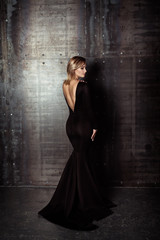 Fototapeta premium Beautiful model posing in sexy dress at black studio