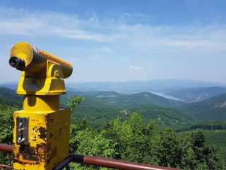 Old and dirty panoramic binoculars besides a beautiful view
