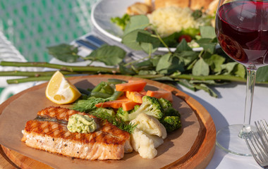 Vegetables and grilled meat on a wooden board