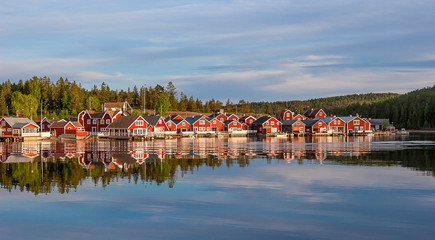 Fototapeta na wymiar red houses at sunset in the fishing village of Norfaellsviken, Höga Kusten, Sweden