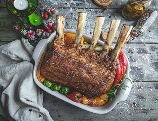 Grilled roasted rack of veal lamb chops with vegetables in ceramic baking dish. New Year christmas composition,decoration.
