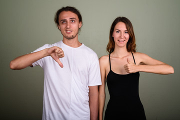 Young handsome man and young beautiful woman together against co