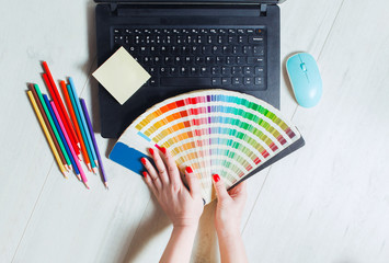 Woman designer chooses color from color palettes