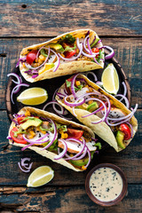 Mexican tacos with chicken meat, vegetables and fresh greens