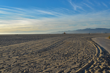 Fototapeta premium Sand Strand blauer Himmel und Berge im Hintergrund 
