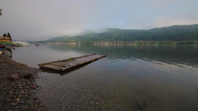 summer landscape in the mountains, wooden old pier on the lake in the early morning in the fogon the lake in the early morning in the fog