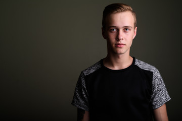 Fototapeta premium Young handsome man with blond hair against colored background