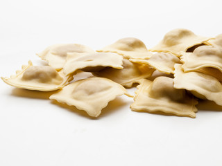 Primer plano frontal de varios raviolis sobre un fondo blanco