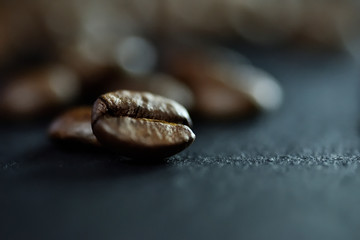 Focus sur un seul grain de caf&eacute; sur un fond de nombreux grains de caf&eacute; sur un tableau noir de pierre