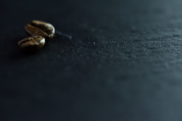 Focus sur un seul grain de café sur un fond de nombreux grains de café sur un tableau noir de pierre