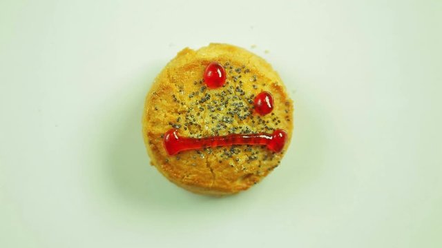 Cookies with painted funny emoticon muzzle emotion discontent. Movement in a circle