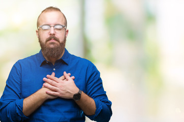 Naklejka na ściany i meble Young caucasian hipster man wearing glasses over isolated background smiling with hands on chest with closed eyes and grateful gesture on face. Health concept.