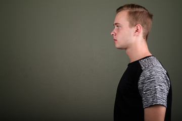 Young handsome man with blond hair against colored background