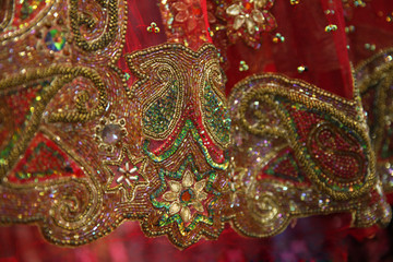 Sparkling gold embroidery, green and colorful sequins, stones, rhinestones