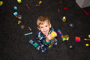 Naklejka premium happy boy playing with toys, top view