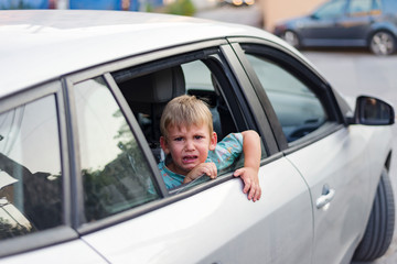 child separated from one parent leaving in a car, sad and crying
