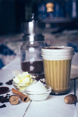 Bulletproof coffee. Ketogenic diet coffee with coconut oil and butter (ghee). Cup of bulletproof coffee and ingredients, paleo diet. On white wooden background