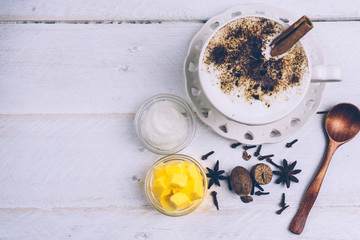 Bulletproof coffee. Ketogenic diet coffee with coconut oil and butter (ghee). Cup of bulletproof coffee and ingredients, paleo diet. On white wooden background