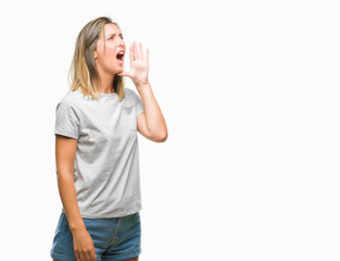 Young beautiful woman over isolated background shouting and screaming loud to side with hand on mouth. Communication concept.
