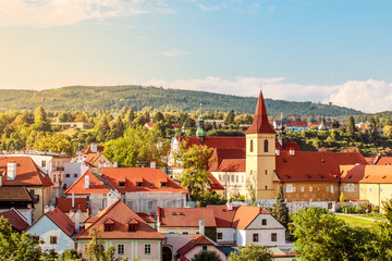 Fototapeta premium Cesky Krumlov, UNESCO, Czech Republic. Sunset aerial view of the old town architecture with red rooftops and houses.