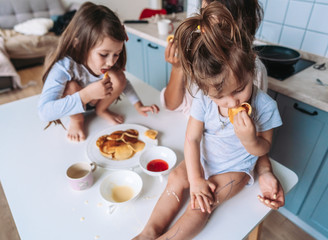 Mom and two daughters eat pancakes