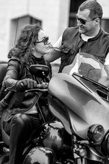 Fototapeta na wymiar Beautiful couple of bikers in leather clothes on a motorcycle