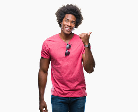 Afro american man over isolated background smiling with happy face looking and pointing to the side with thumb up.