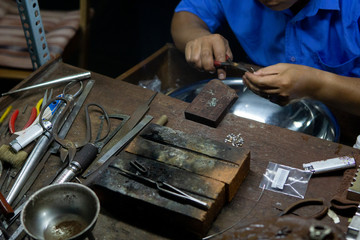 Close hand jeweler stringing pearls on a necklace. Worker in the production of Pearl Necklace