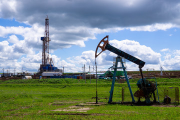 The beam pumping unit is homework, sunset in oil field. Oil pump oil rig energy industrial machine...