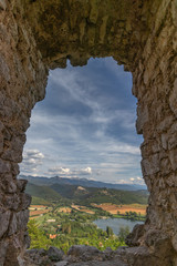 Beautiful lake Piediluco view and the ancient town Labro on the hill from the window of an old ruined castle (Rocca di Piediluco). Terni, Umbria, Italy