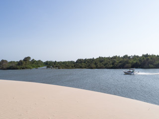 Amazing view of a Brazilian mangrove, white dune, forest and a boat sailing, Brazil, Parnaíba. 