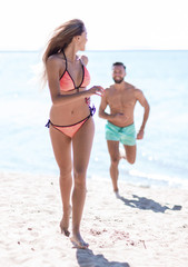Happy fun beach vacations couple walking together laughing havin
