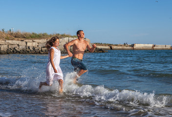 running happy couple on the beach
