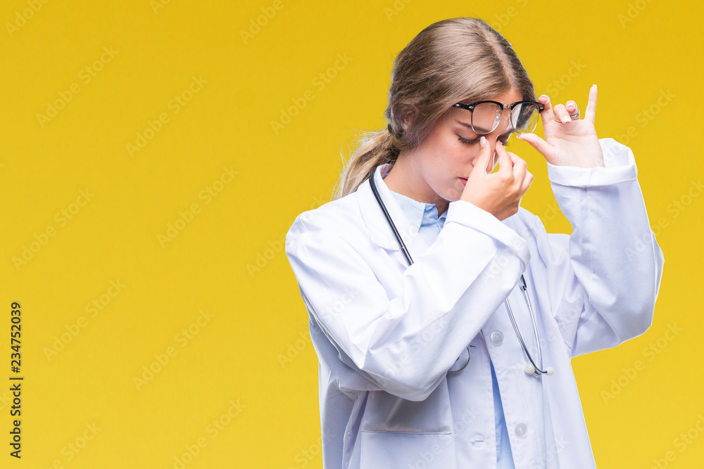 Poster Beautiful young blonde doctor woman wearing medical uniform over isolated background tired rubbing nose and eyes feeling fatigue and headache. Stress and frustration concept.