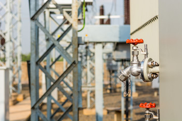 Detail and focus on red oil release valve of power transformer.