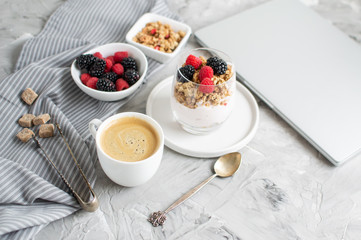 Healthy Breakfast Cup of Coffee Greek Yogurt with Homemade Granola, Berries, Raspberries and Blackberries Work Laptop Morning Concept