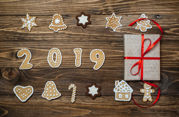 Christmas cookies with the numbers 2019 on a wooden background with Christmas presents