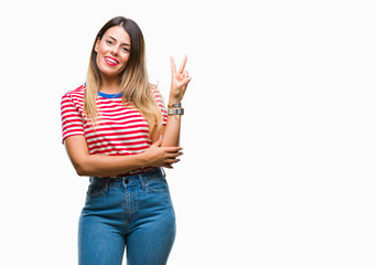 Young beautiful woman casual look over isolated background smiling with happy face winking at the camera doing victory sign. Number two.