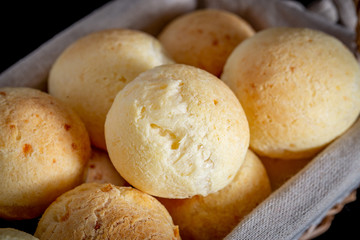 Fototapeta na wymiar Brazilian homemade cheese bread, AKA 'pao de queijo' in a rustic basket.