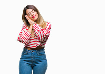 Young beautiful woman casual stripes winter sweater over isolated background sleeping tired dreaming and posing with hands together while smiling with closed eyes.