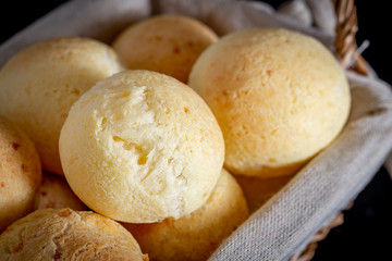 Brazilian homemade cheese bread, AKA 'pao de queijo' in a rustic basket.