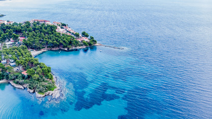 Drone aerial view of sea shore on stones and blue water