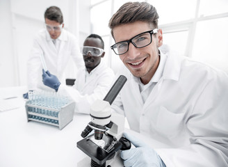close up.a young scientist uses sitting at a lab table.