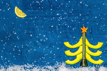 Obraz na płótnie Canvas Bright flat food concept of celebrating Christmas and New Year. Christmas tree made from avocado, cucumber and carrots, moon made from lemon wedge, snow from sea salt. Top view Copy space