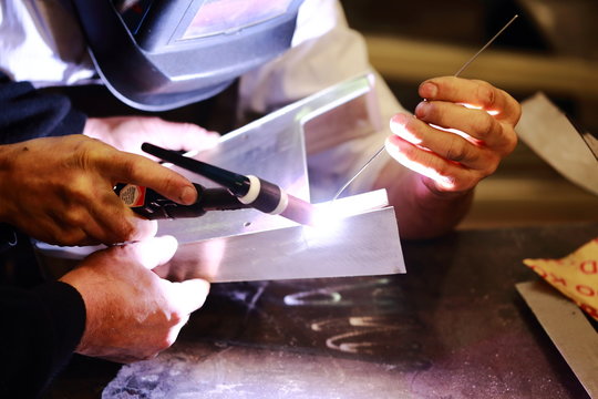 worker tig welding metal