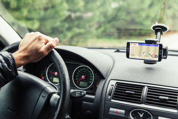 a driver in a car performs tasks necessary to steer the vehicle