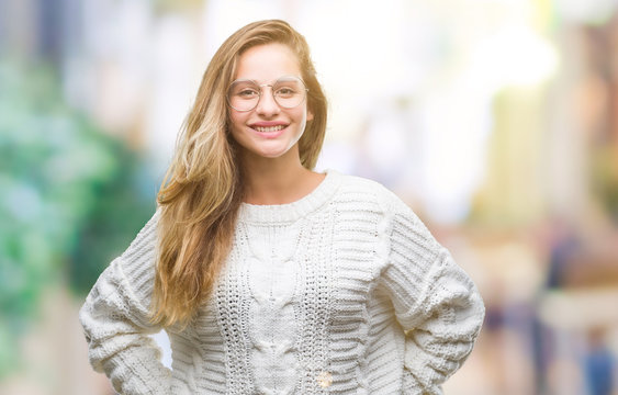 Young beautiful blonde woman wearing winter sweater and sunglasses over isolated background with a happy and cool smile on face. Lucky person.