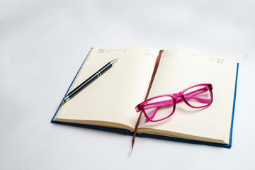 Fototapeta premium Notebook with glasses and pen, Book with glasses, Blue notebook with glasses, Book with cup of tea