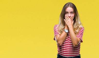 Young beautiful blonde woman over isolated background shocked covering mouth with hands for mistake. Secret concept.